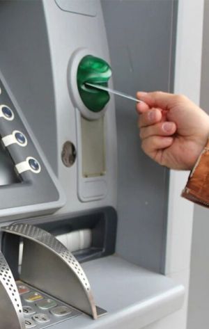 woman holding her banking card in a cash machine